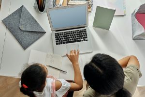 A tutor and student working at a laptop